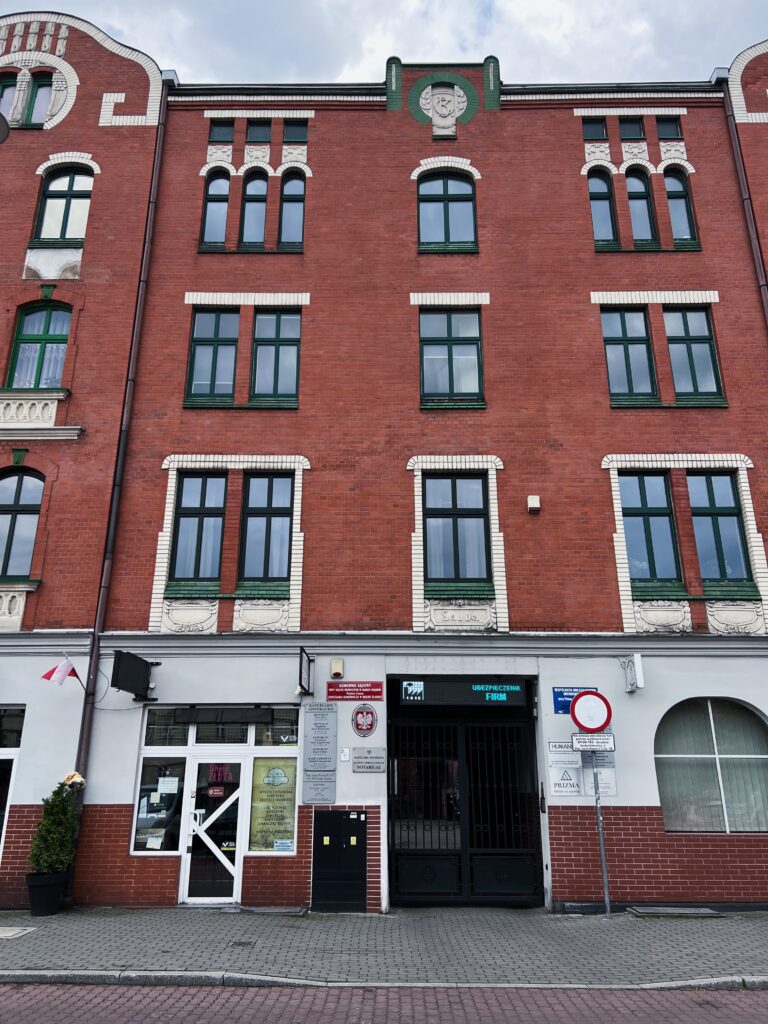 Elewacja budynku z szyldem "Notariusz" -wejście do klatki